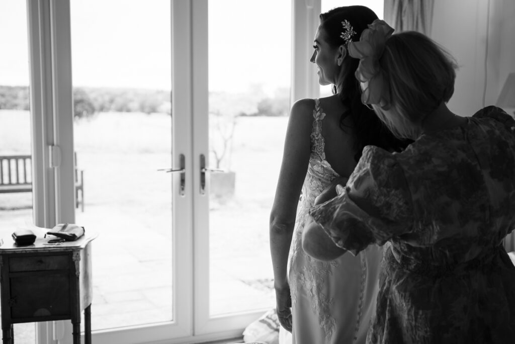 Bride getting into the dress with her mother's help