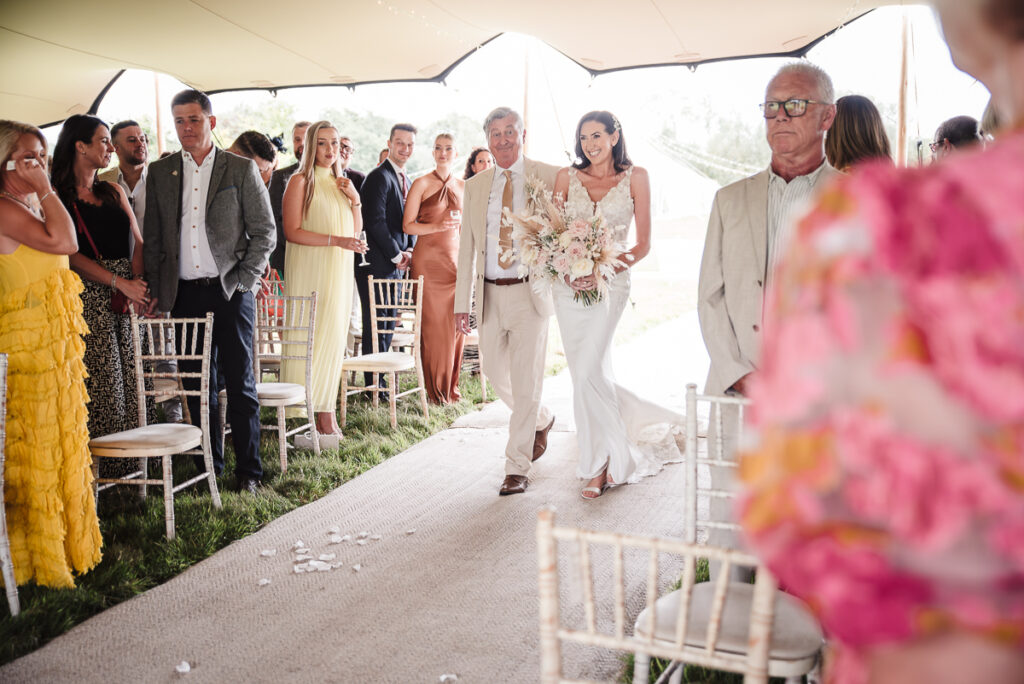 Bride walks down the aisle towards groom