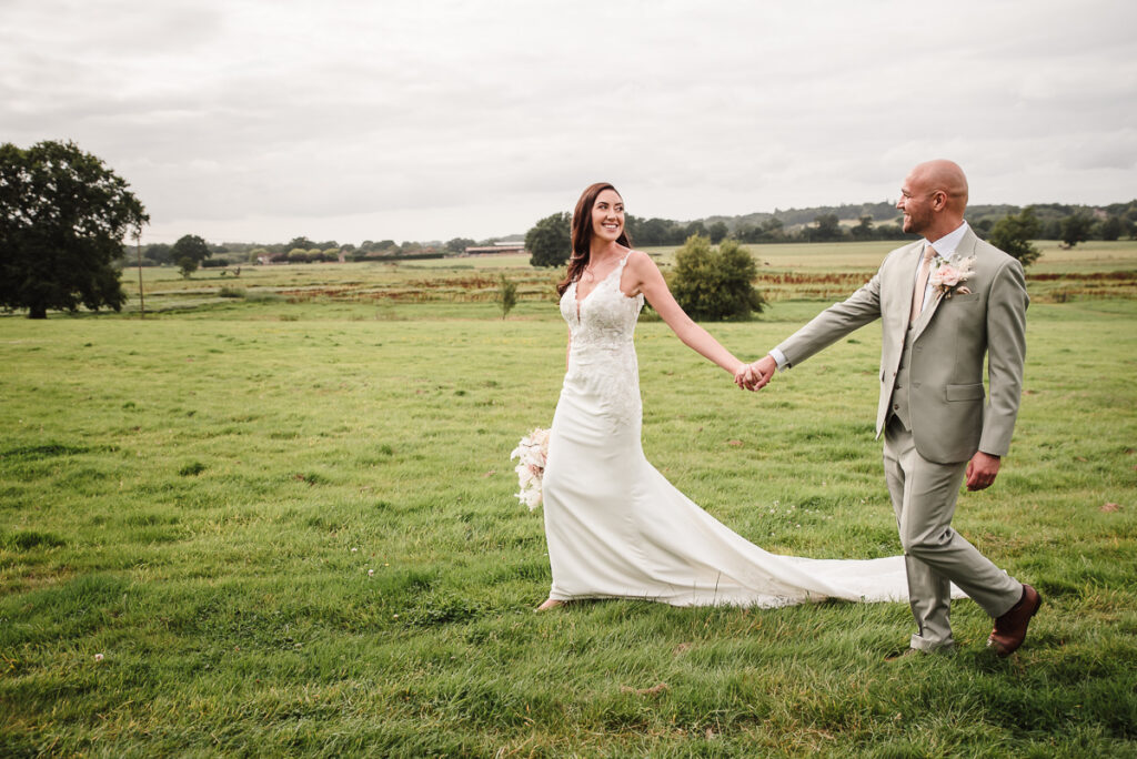 Bride and groom holding hand and walking away during couple's photos