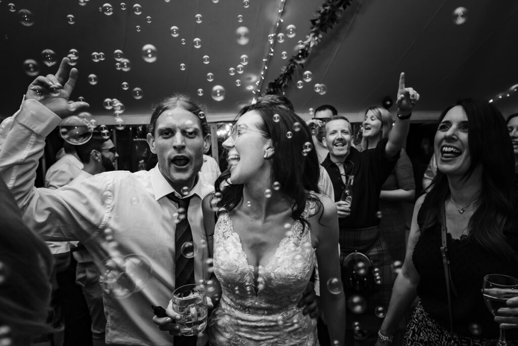 Bride dancing around bubbles on the dance floor during the party