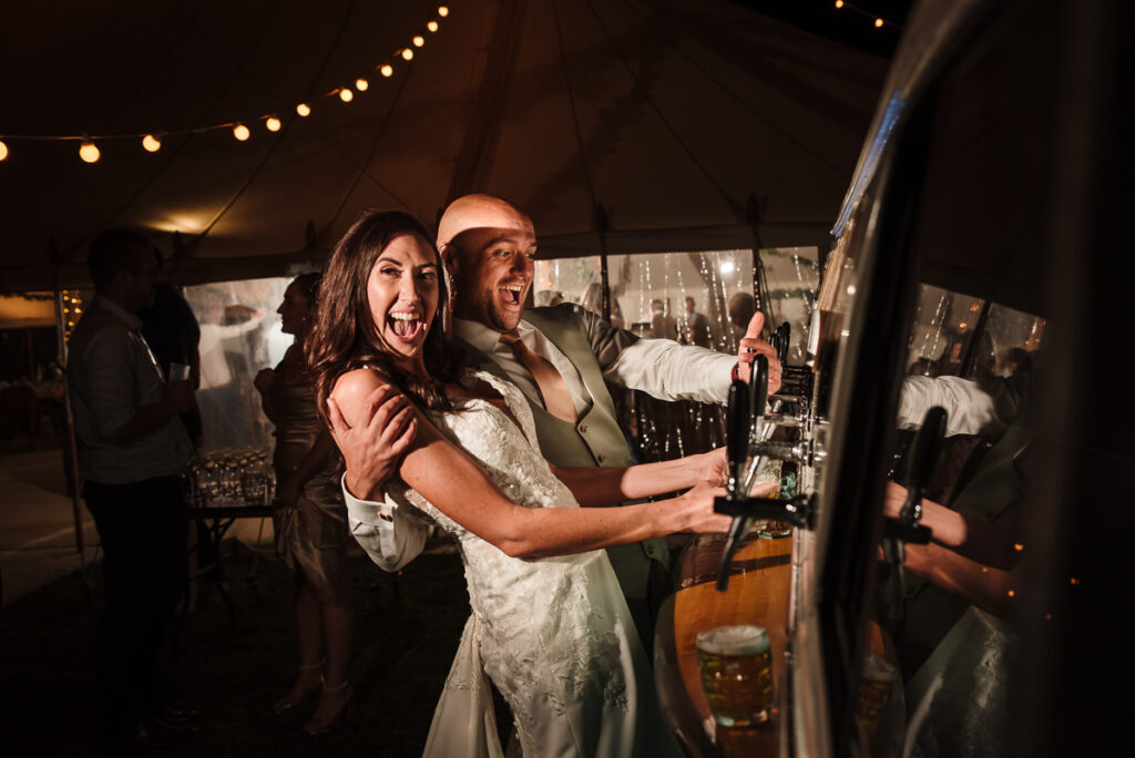 Bride and groom pouring one last pint at their DIY wedding at the House on the Brooks